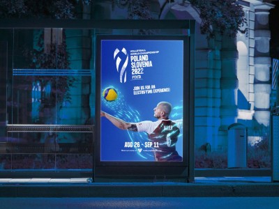 man wearing grey t-shirt standing in front of man sitting on chair