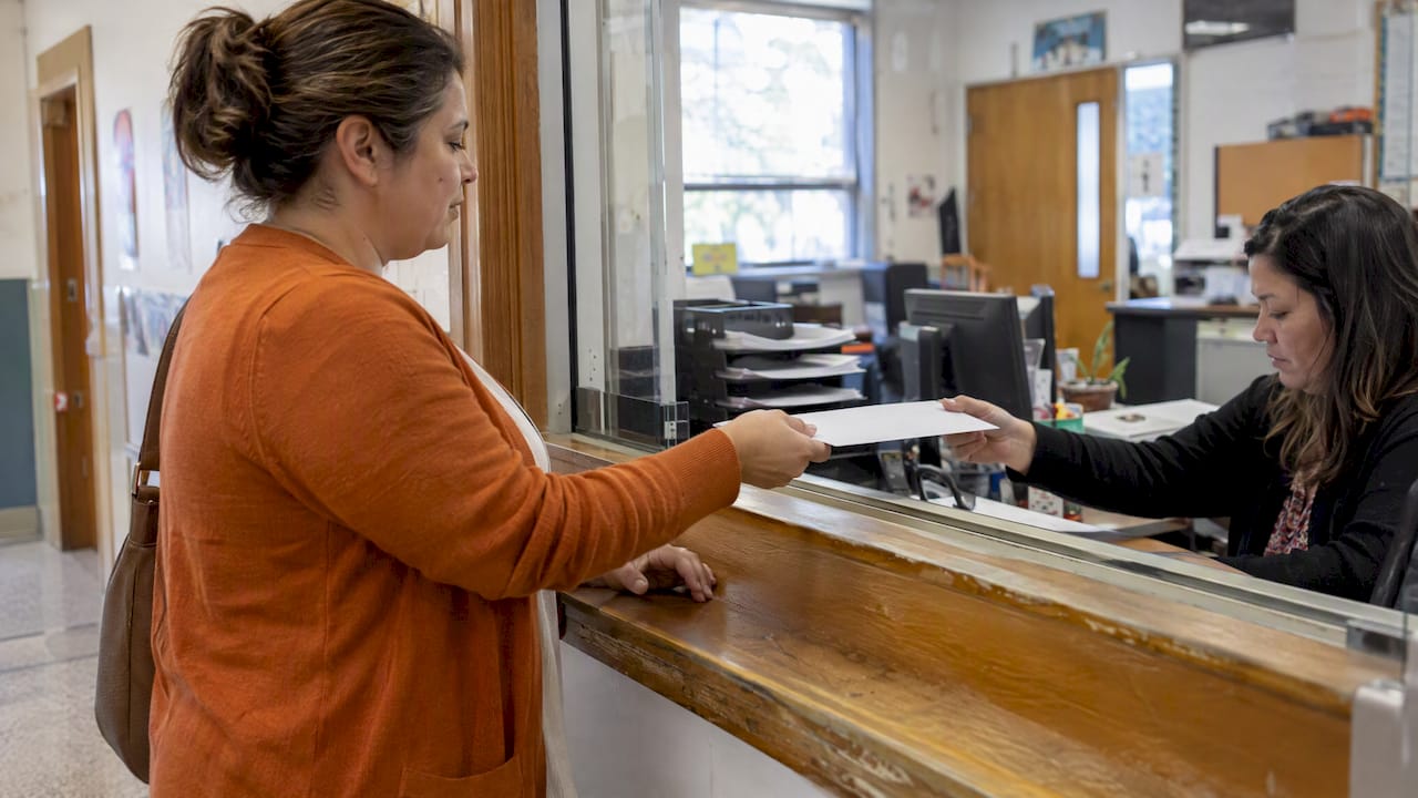 La cuidadora entrega la solicitud en la escuela