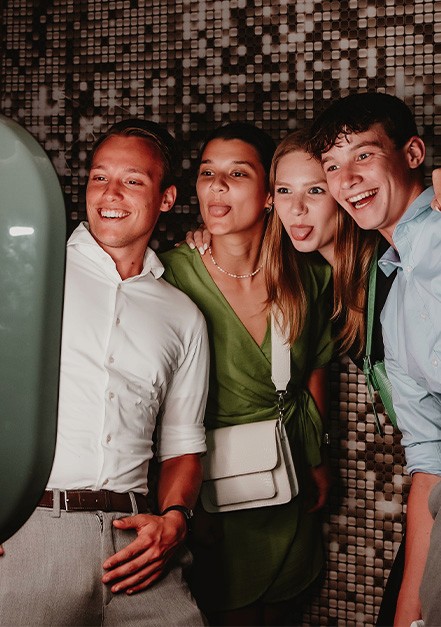 Jeugd staat voor de photobooth, steken tong uit en lachen.