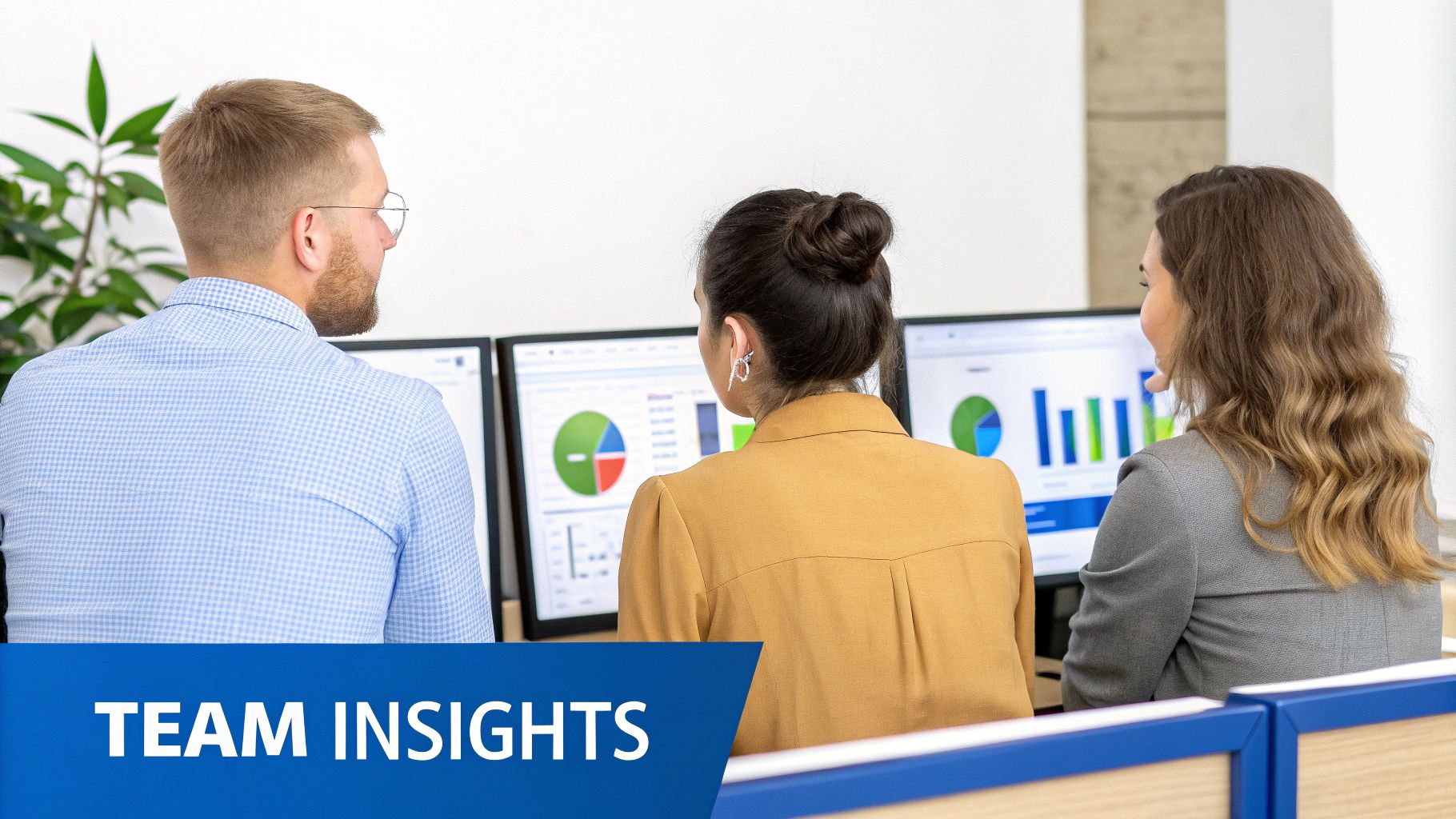 Three colleagues from behind viewing multiple computer screens displaying data charts and graphs in an office.
