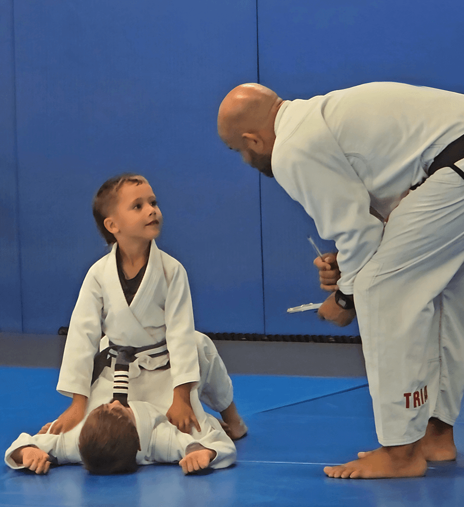 Two boys in white and blue gis preparing to spar on the mat