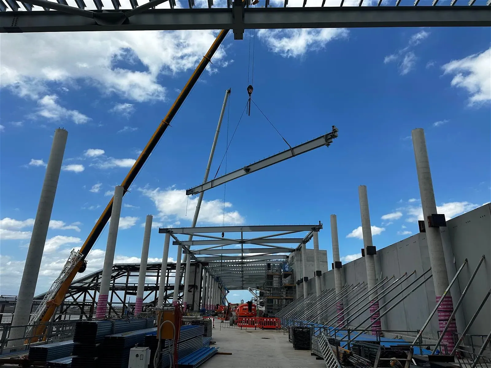 Crane lifting steel beam at construction site