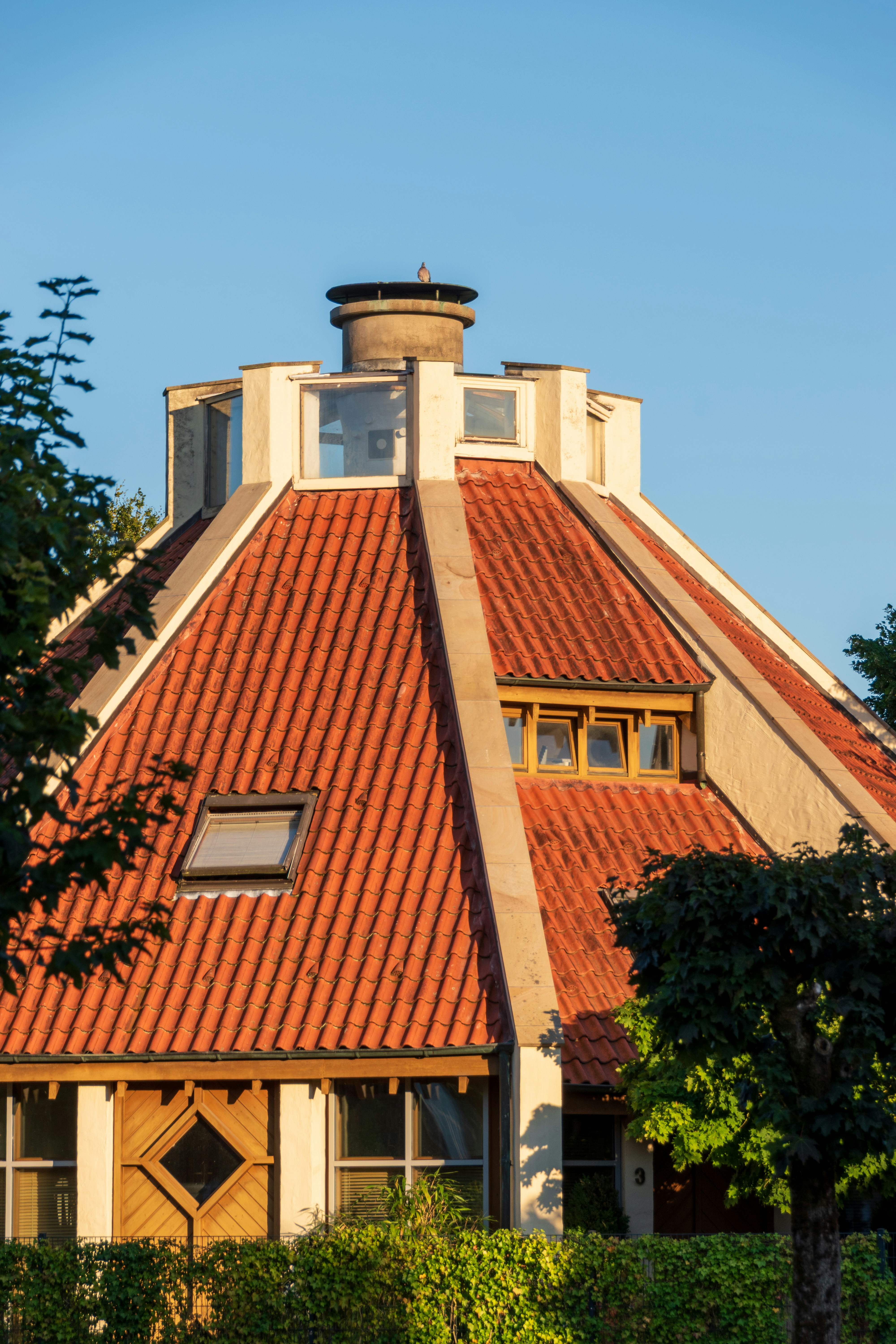Unique circular house with red tiled roof and windows