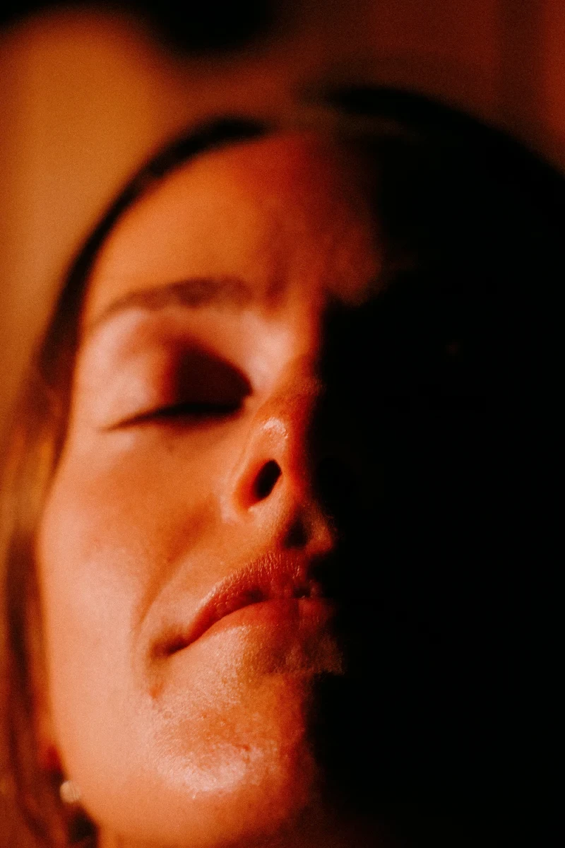 Close-up of a person resting with eyes closed during a meditative heat ritual in Vancouver.