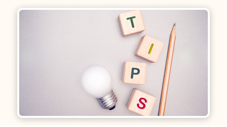 Ampoule, cubes en bois formant le mot “TIPS” et crayon sur fond clair