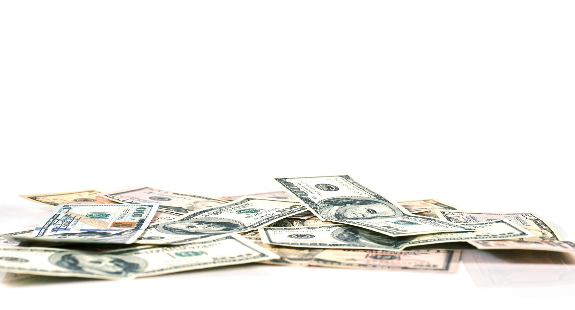 um pequeno amontoado de notas de dólares em um fundo branco