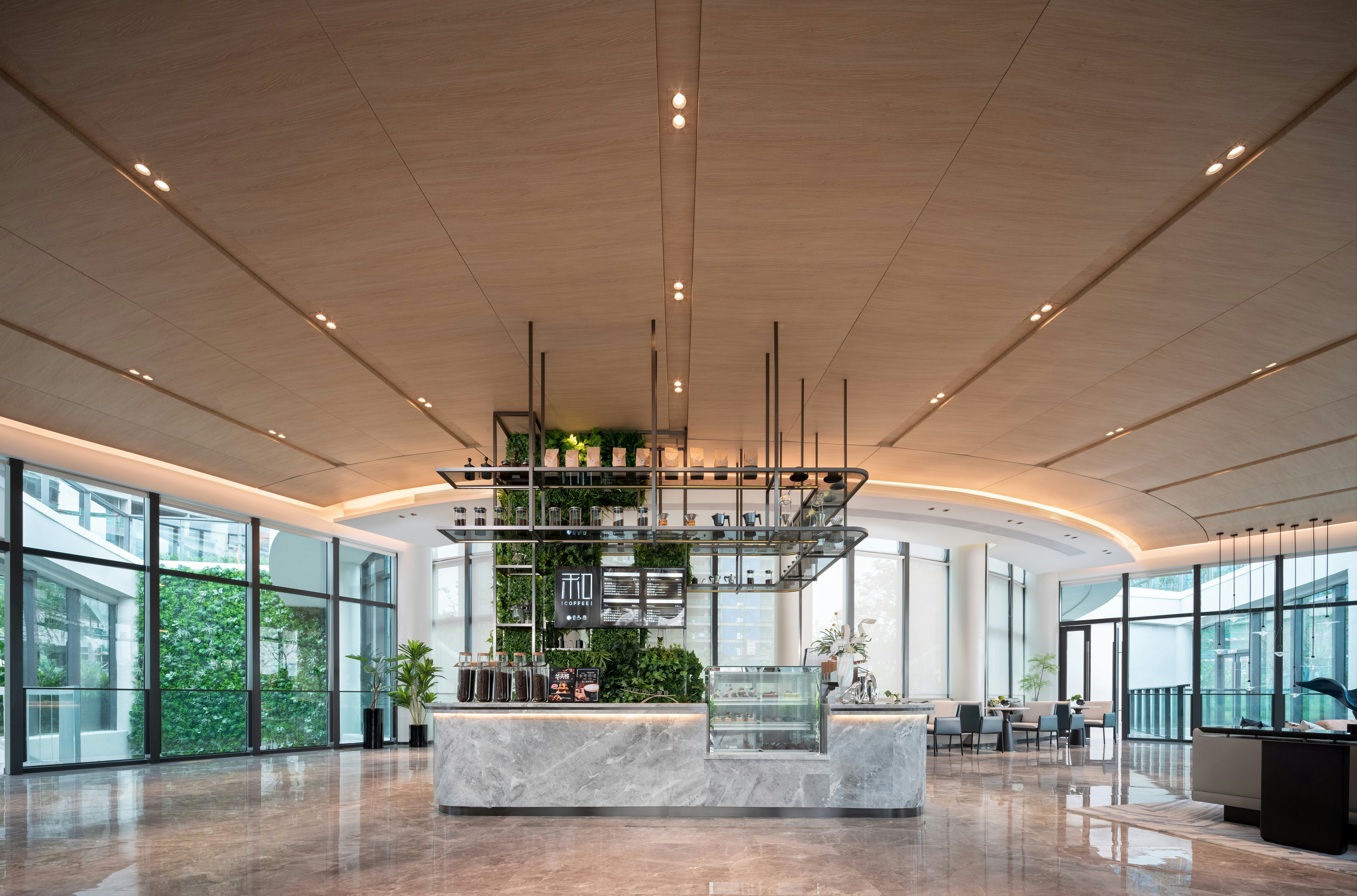 Modern lobby with a central coffee bar and greenery