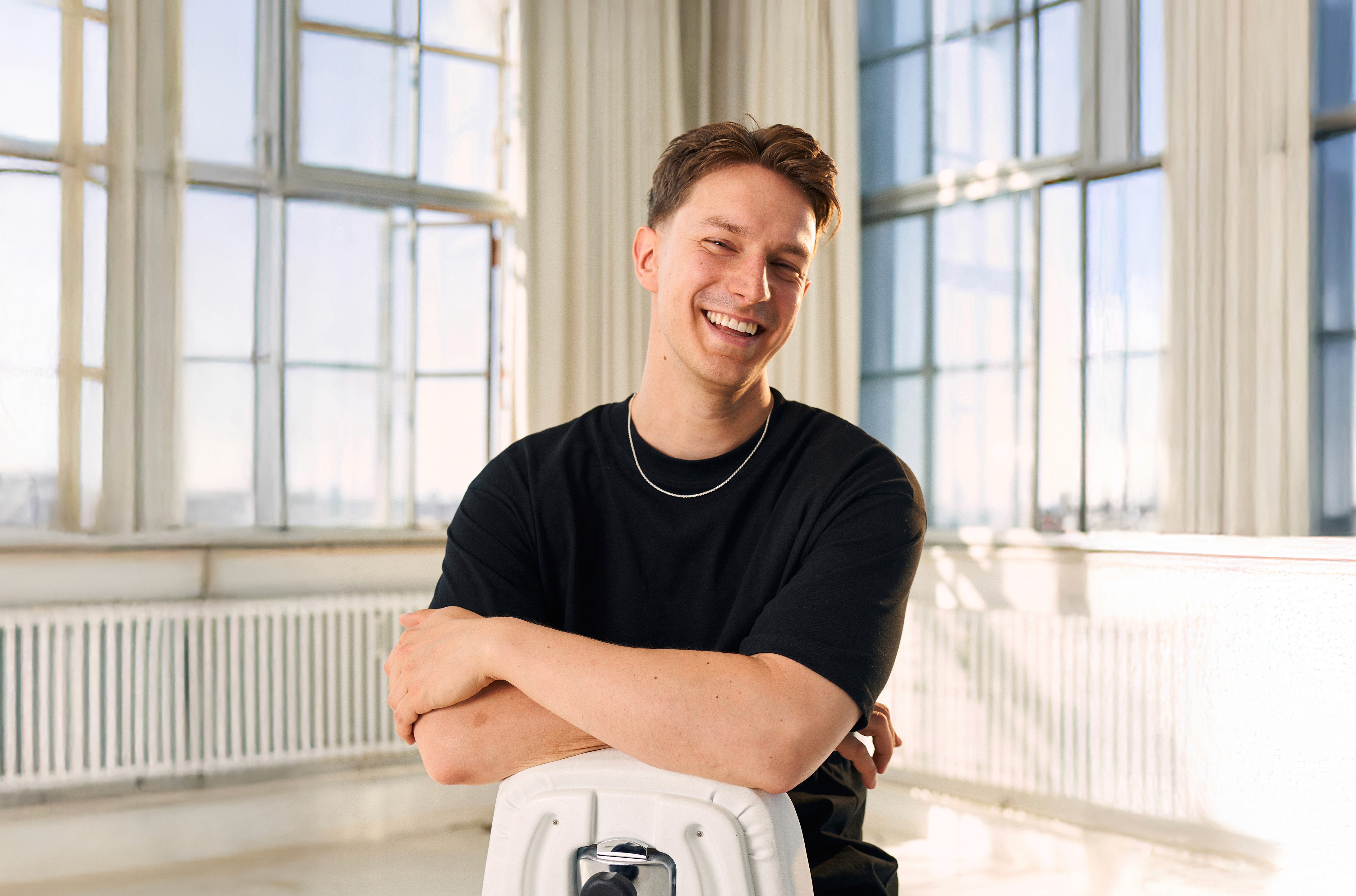Close-up of a yellow tennis ball sitting on a green court, positioned near the white center line.