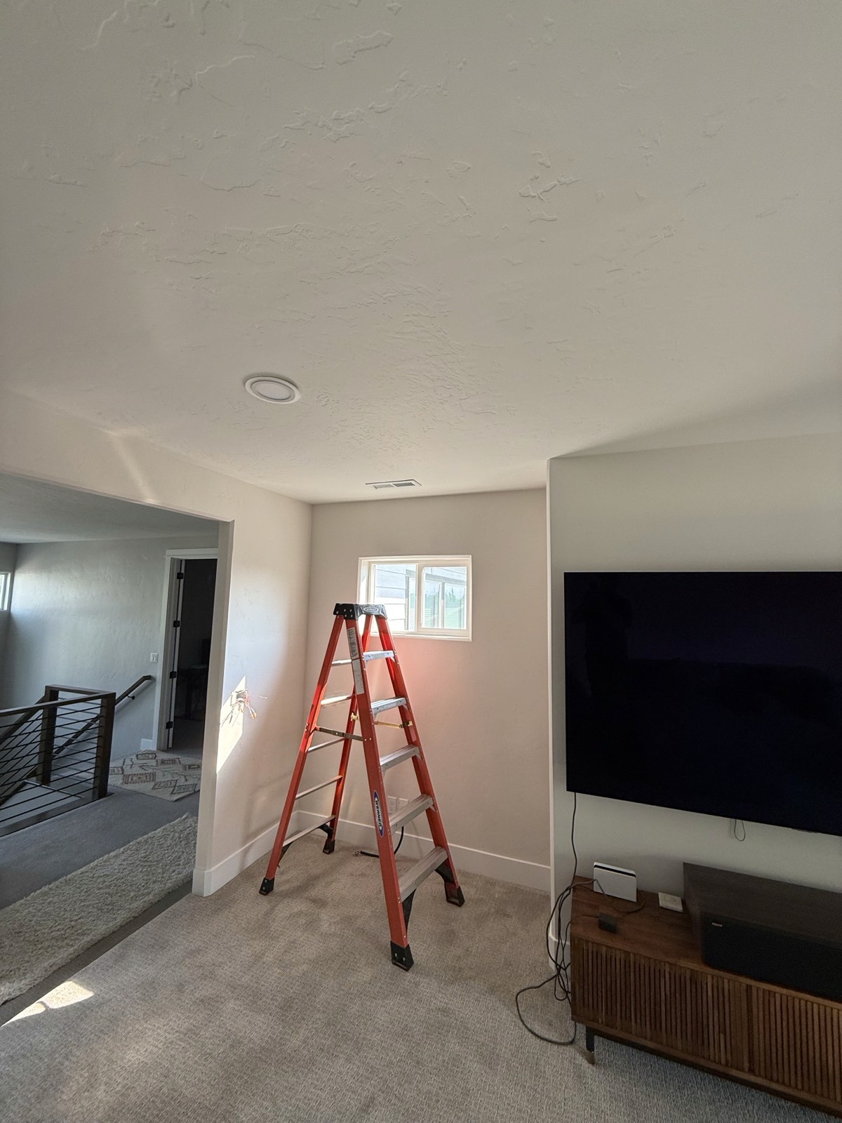 Bonus room mid-install with a ladder and a new ceiling register