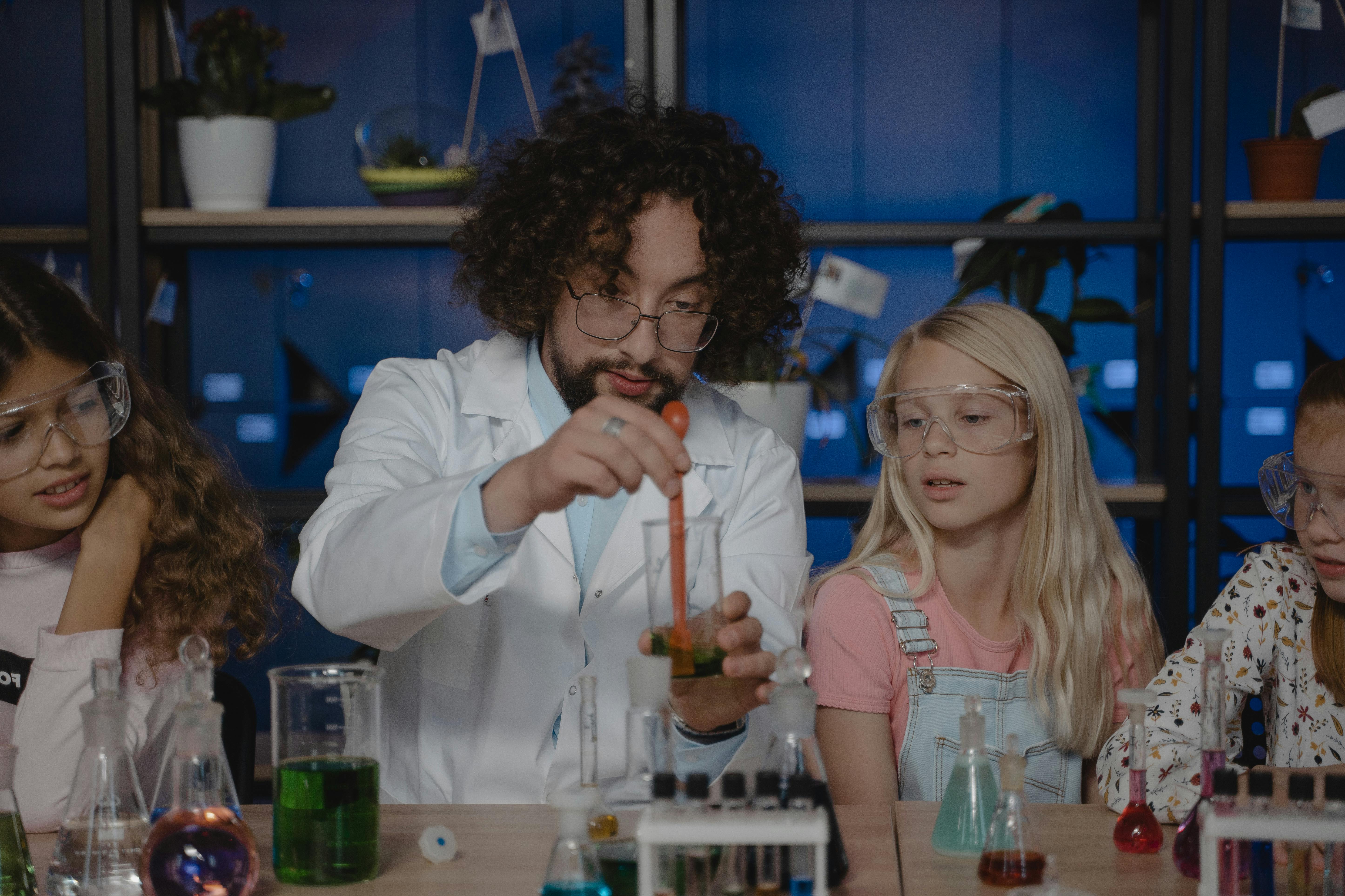 Teacher Mixing a Colored Liquid inside a Beaker during a science class