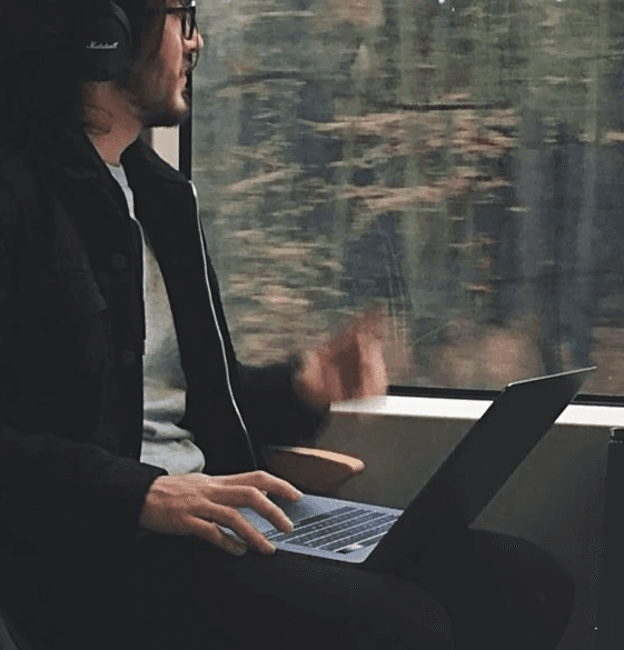 Portrait of man looking to the left and smiling with a dark background