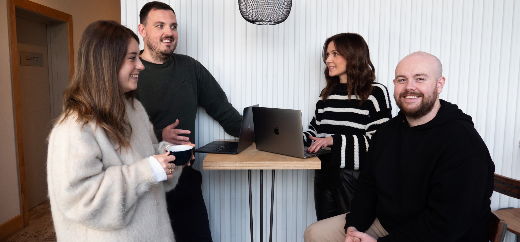 People having a discussion around an open laptop.
