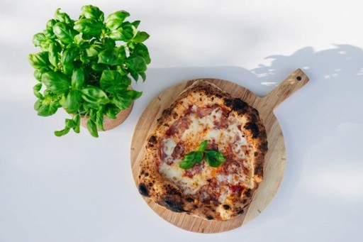 Frisch gebackene neapolitanische Pizza auf einem Holzbrett von Pizzalust – authentisches Live-Catering für eure Hochzeit in Geiselwind