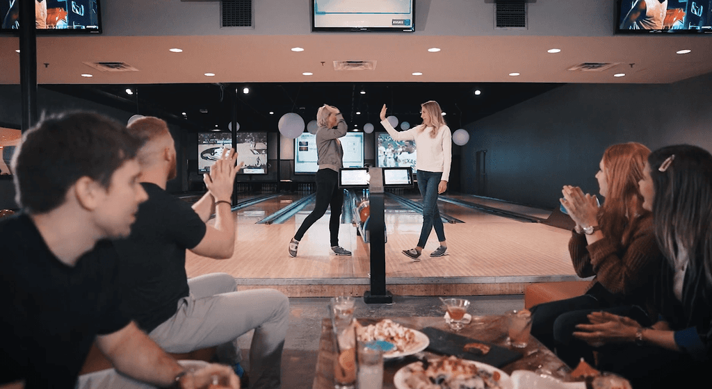 people high 5 on bowling lane