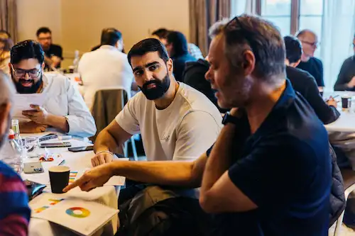 People sitting and working on laptops at a table.