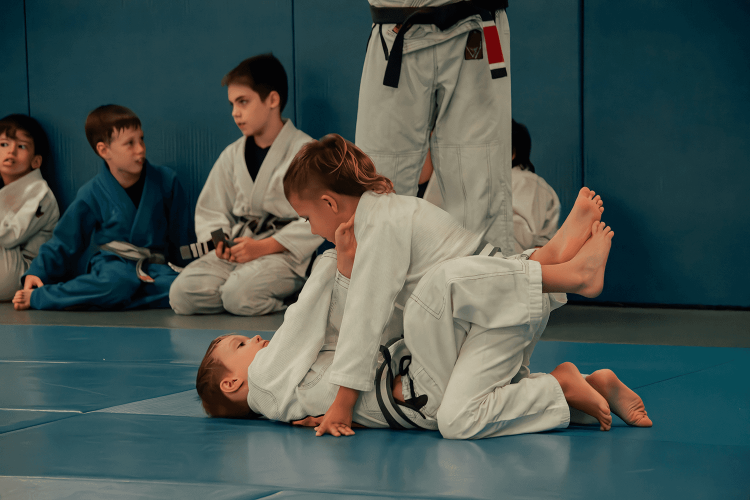 Instructor guiding two young students during class