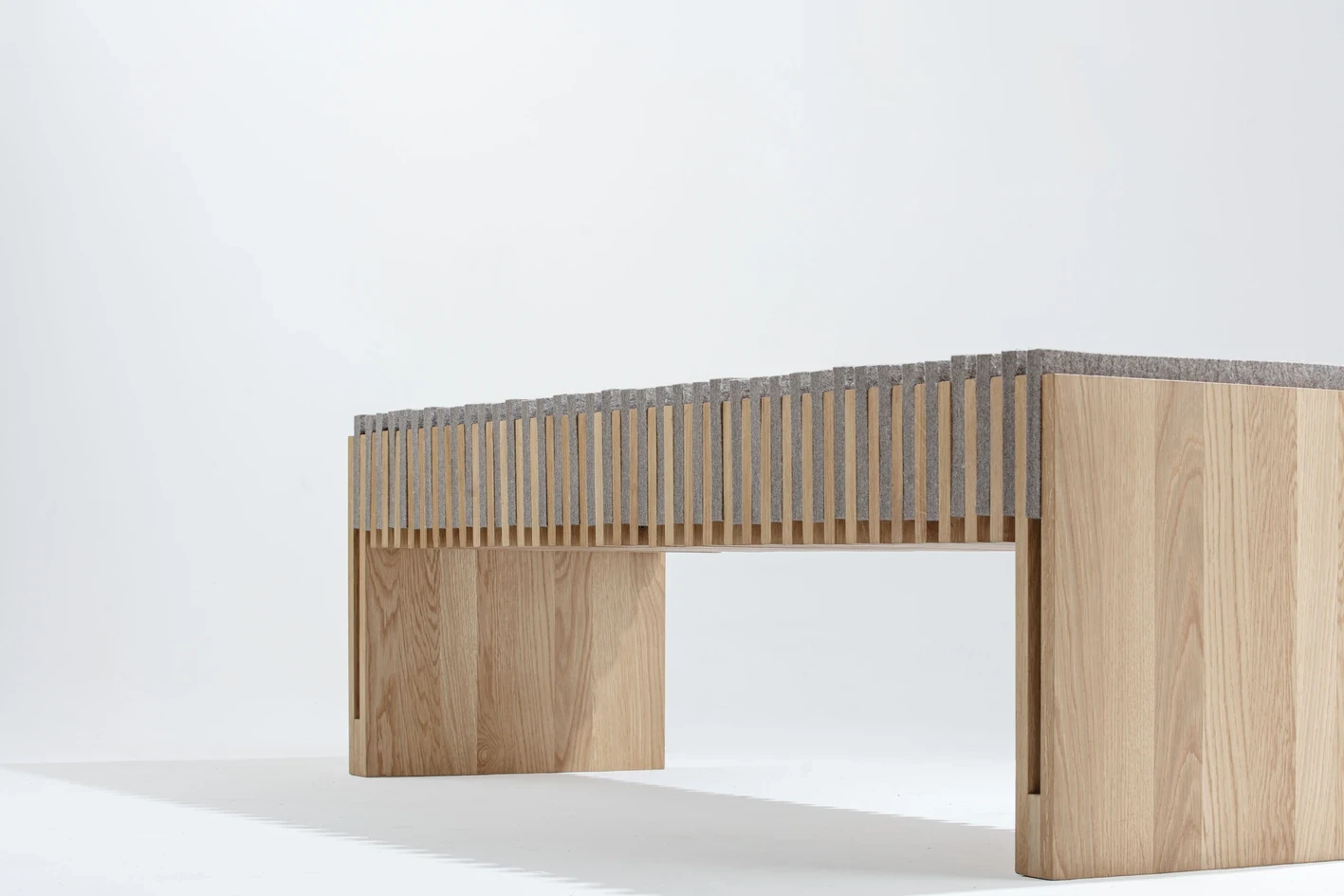 Vue rapprochée de l’assise striée du banc, rythme et texture des matériaux.