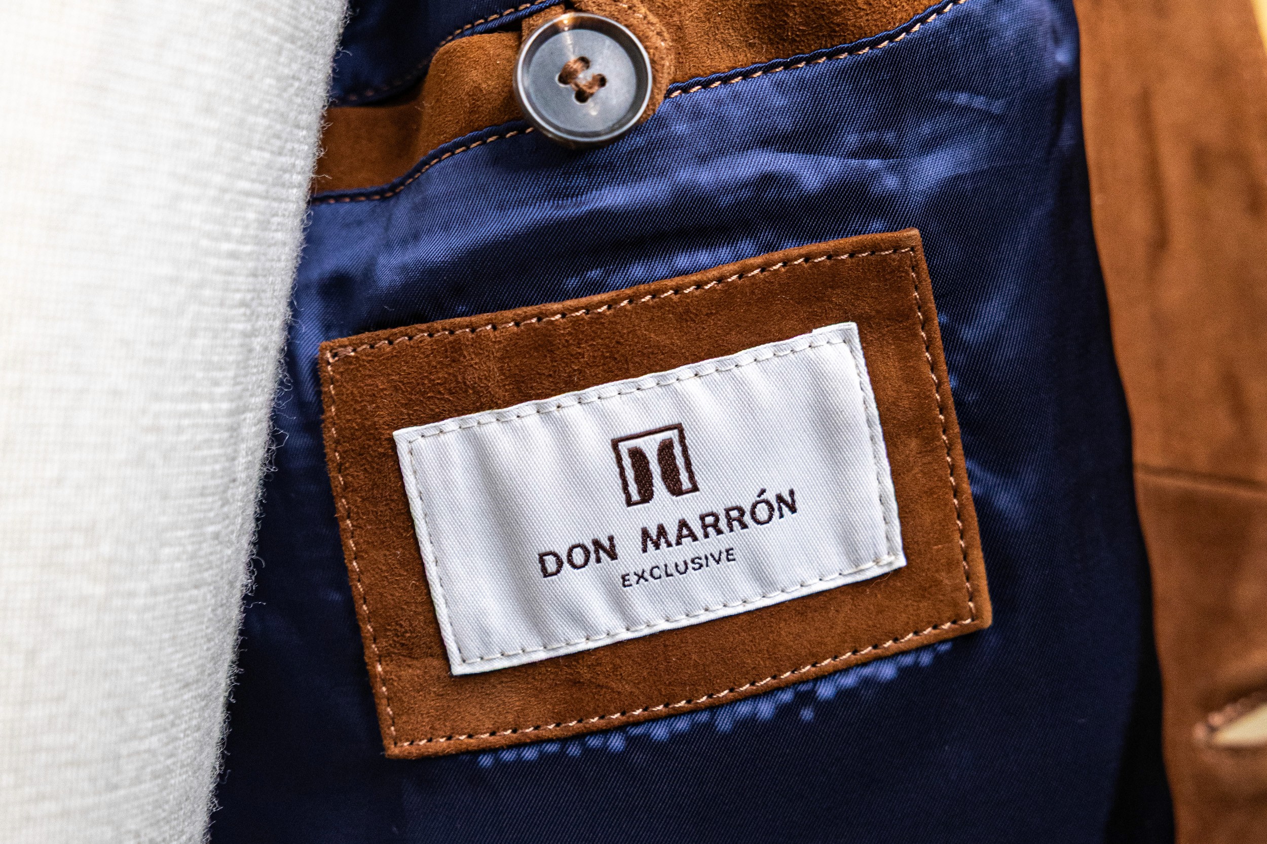 A close-up of Don Marrón’s embossed logo on deep suede — a reflection of timeless craftsmanship and refined luxury in every detail.