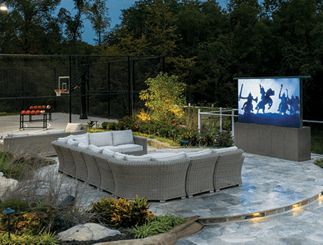 Patio with sectional sofa, basketball court, and outdoor TV.