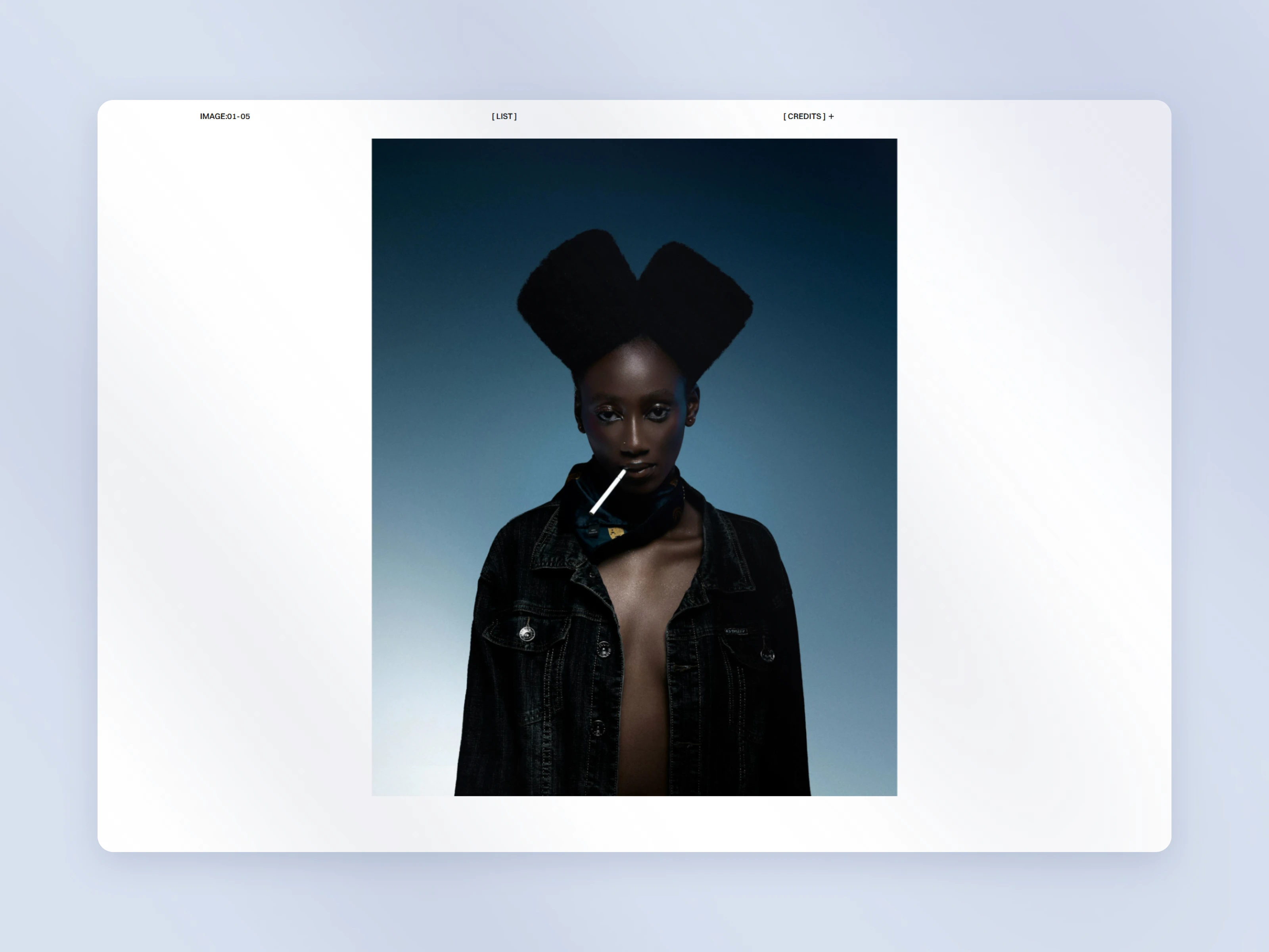 Editorial portrait of a model in denim with sculptural hair and a cigarette against a blue backdrop.