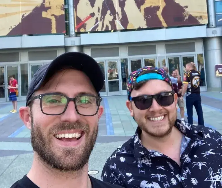 Jared and Freddie stand together at Star Wars Celebration, surrounded by the excitement of the event. Their expressions capture the joy and enthusiasm of being part of the Star Wars fandom at a major convention.