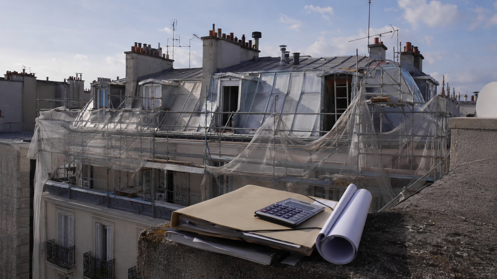 Travaux de toiture en copropriété à Paris avec échafaudage, dossier de financement, calculatrice et plans sur un toit d’immeuble haussmannien