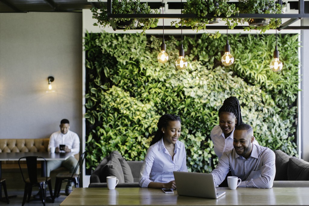 Three team members laughing at their desk 