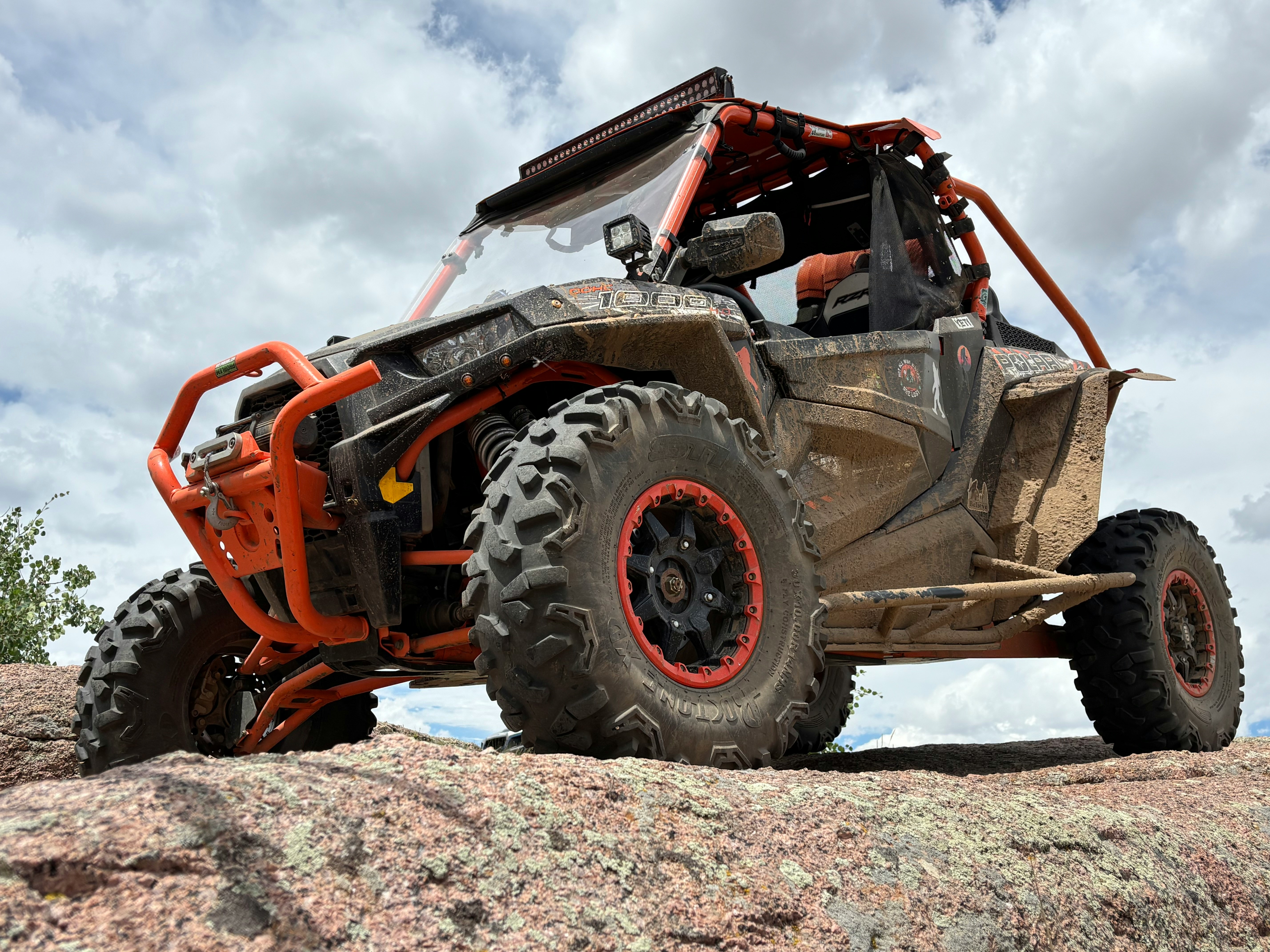 An orange and black off-road vehicle on rocks.
