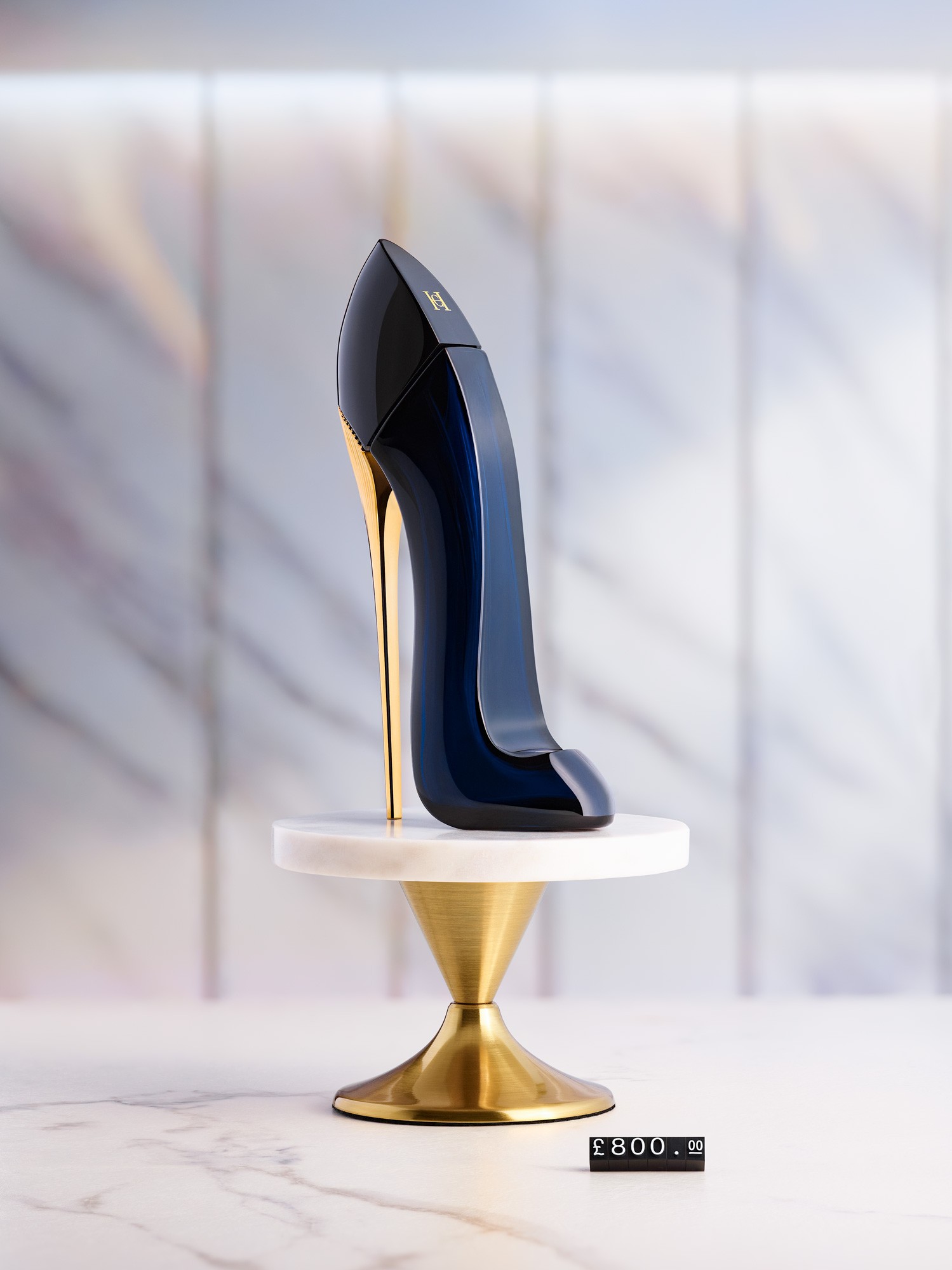A bottle of Carolina Herrera "Good Girl" perfume photographed in a studio where the environment resembles a luxury shoe shop. Photographed by Matthew Brown (A London product photographer).