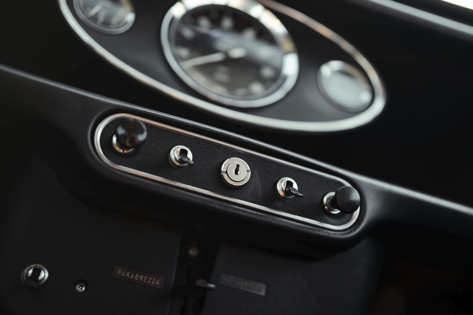 Close-up of a car control panel featuring buttons for various functions, set against a sleek, black background.
