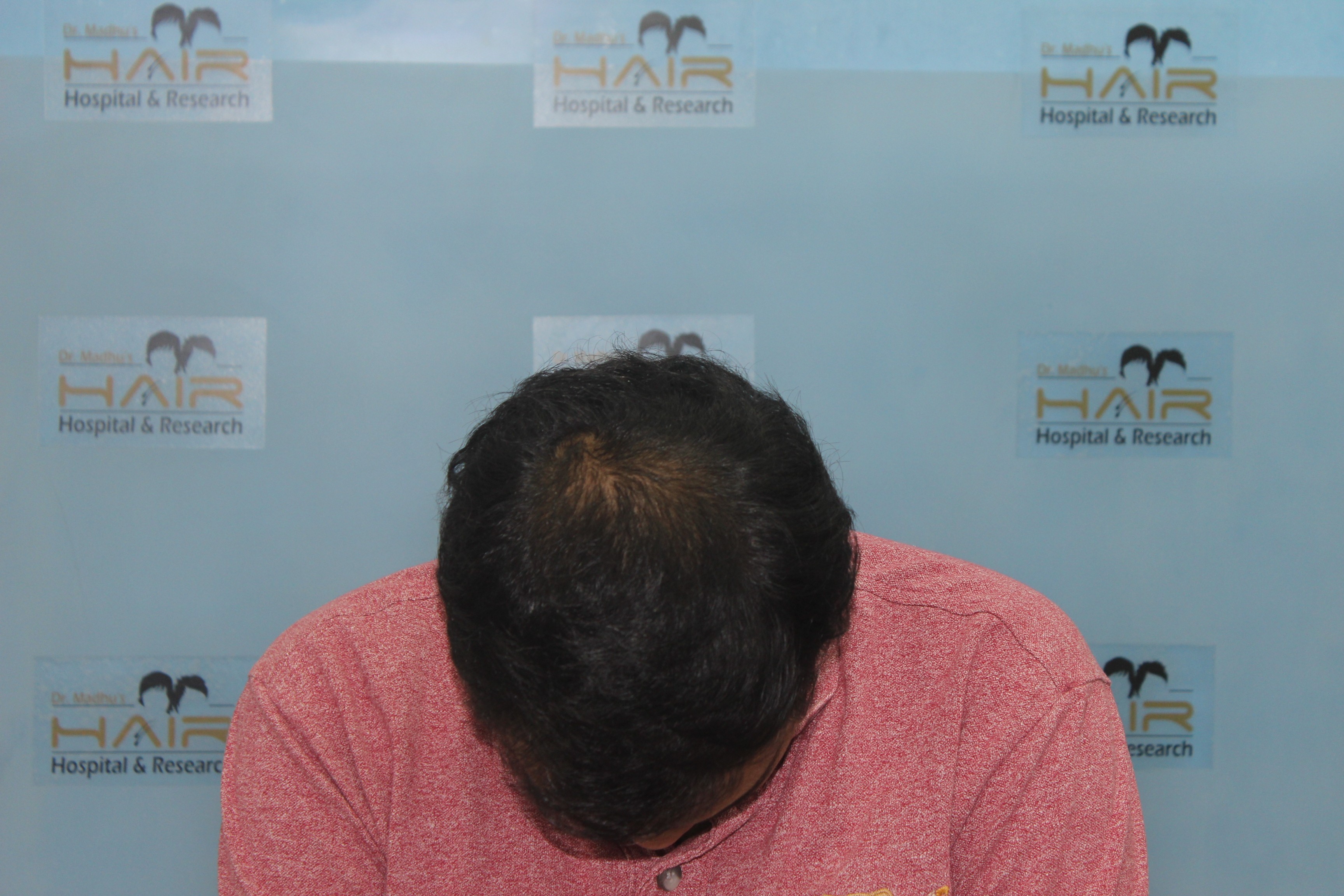 Smiling child in rust sweater and turtleneck seated against light gray background