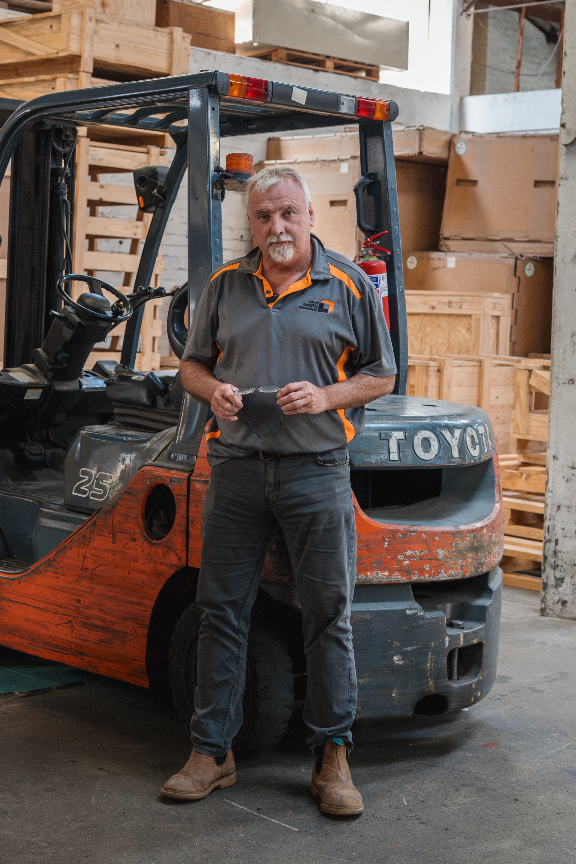 Owen Bottomley, Managing Director of Cargo Handling Specialists, standing in the warehouse in front of a forklift.