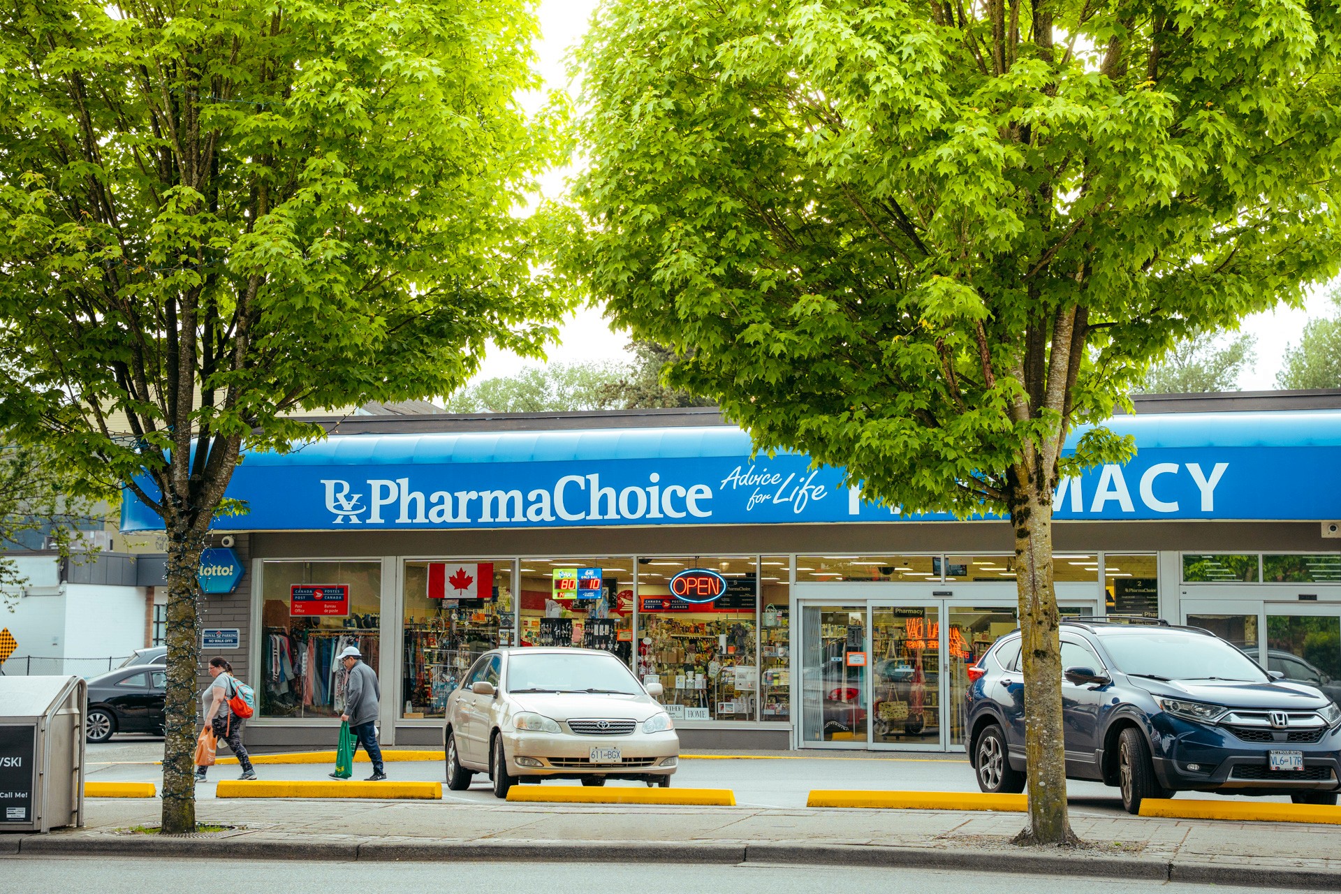 Three athletes resting on a blue running track; one lying on his back and two sitting nearby.