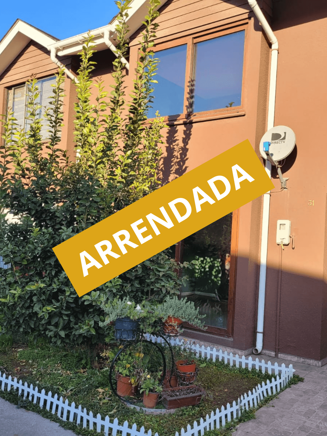 Red wooden harbor house overlooking boats, water, and snow-capped mountains.