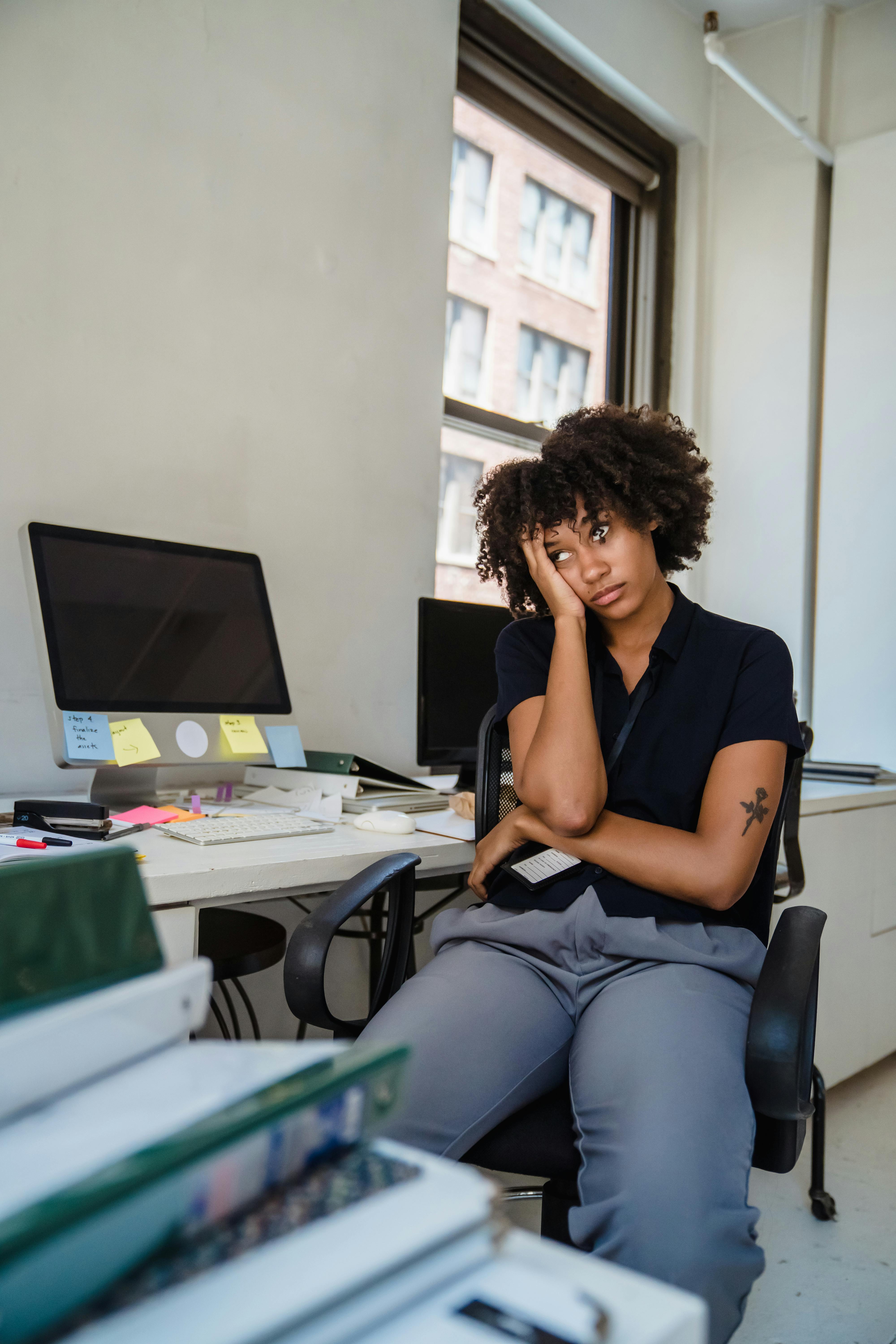 Tired Woman Sitting in Chair at Work
