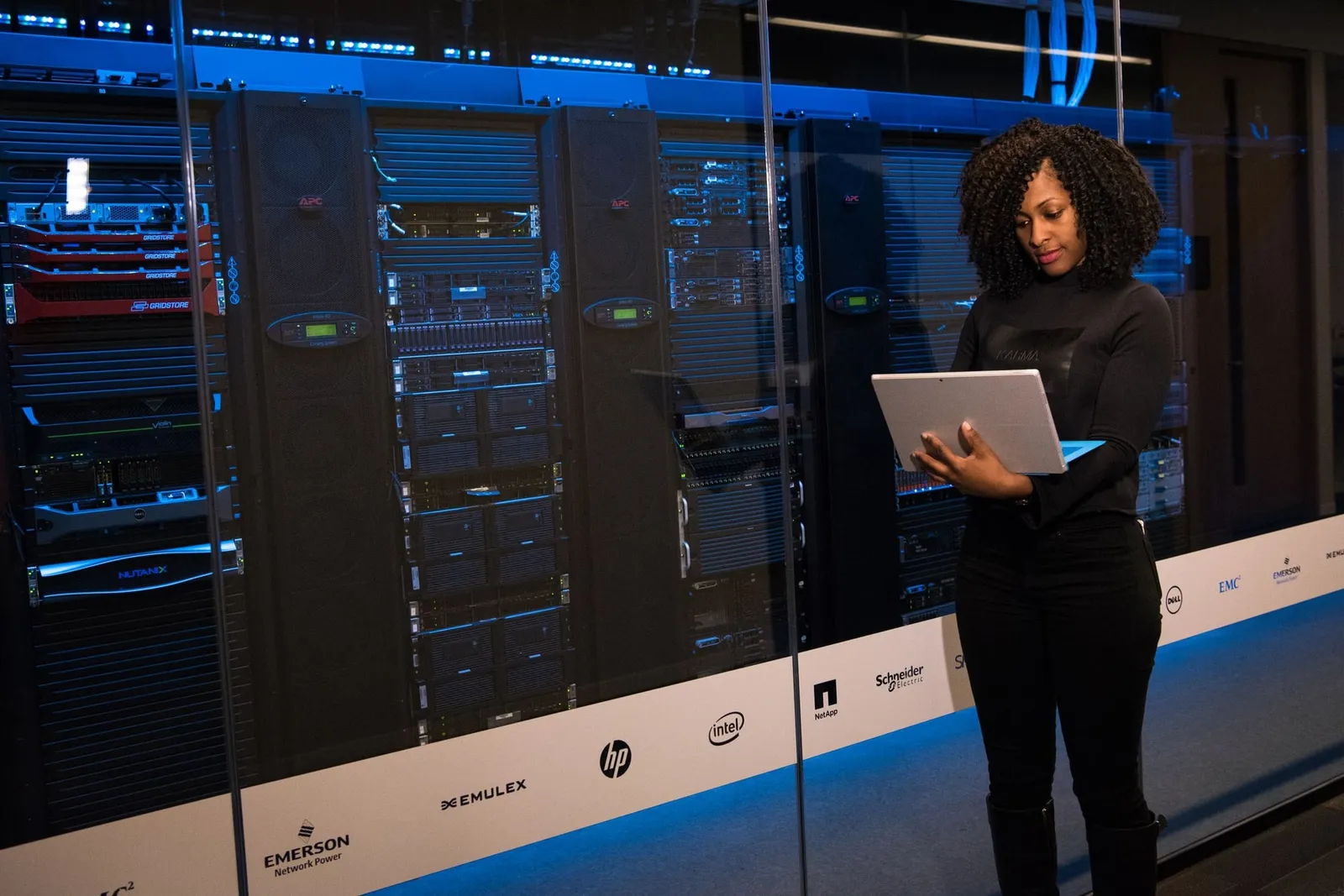 An engineer holding a laptop in a server room