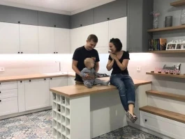 Smiling man with glasses and a beard wearing a peach shirt on a pastel background.