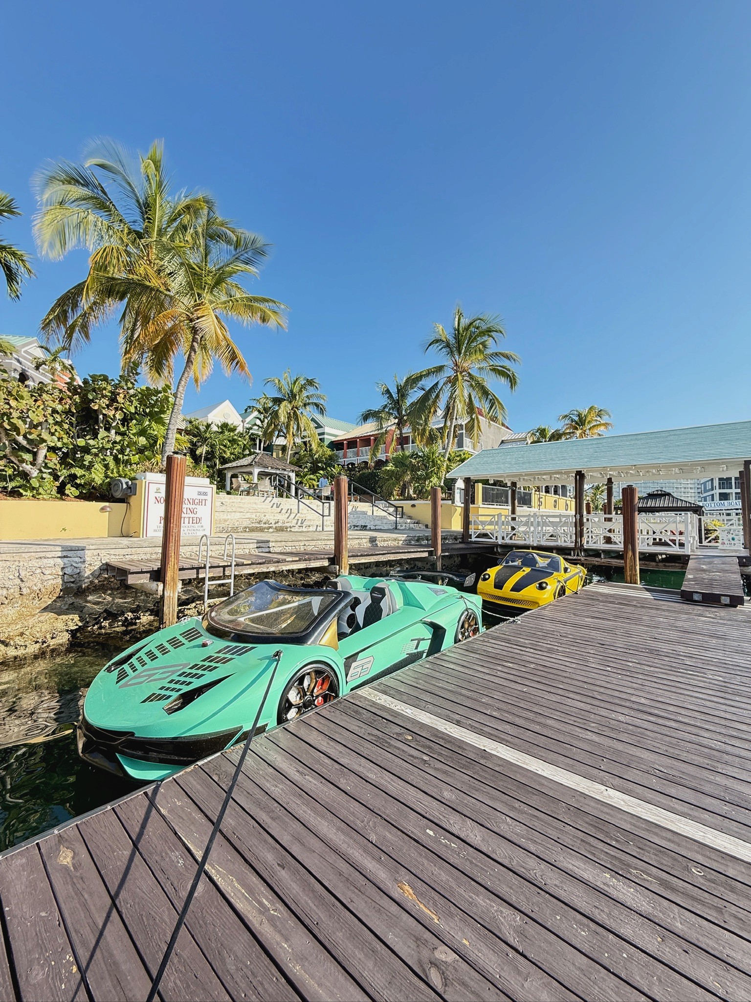 A group of six people gather around a wooden table where an older man in an apron kneads dough