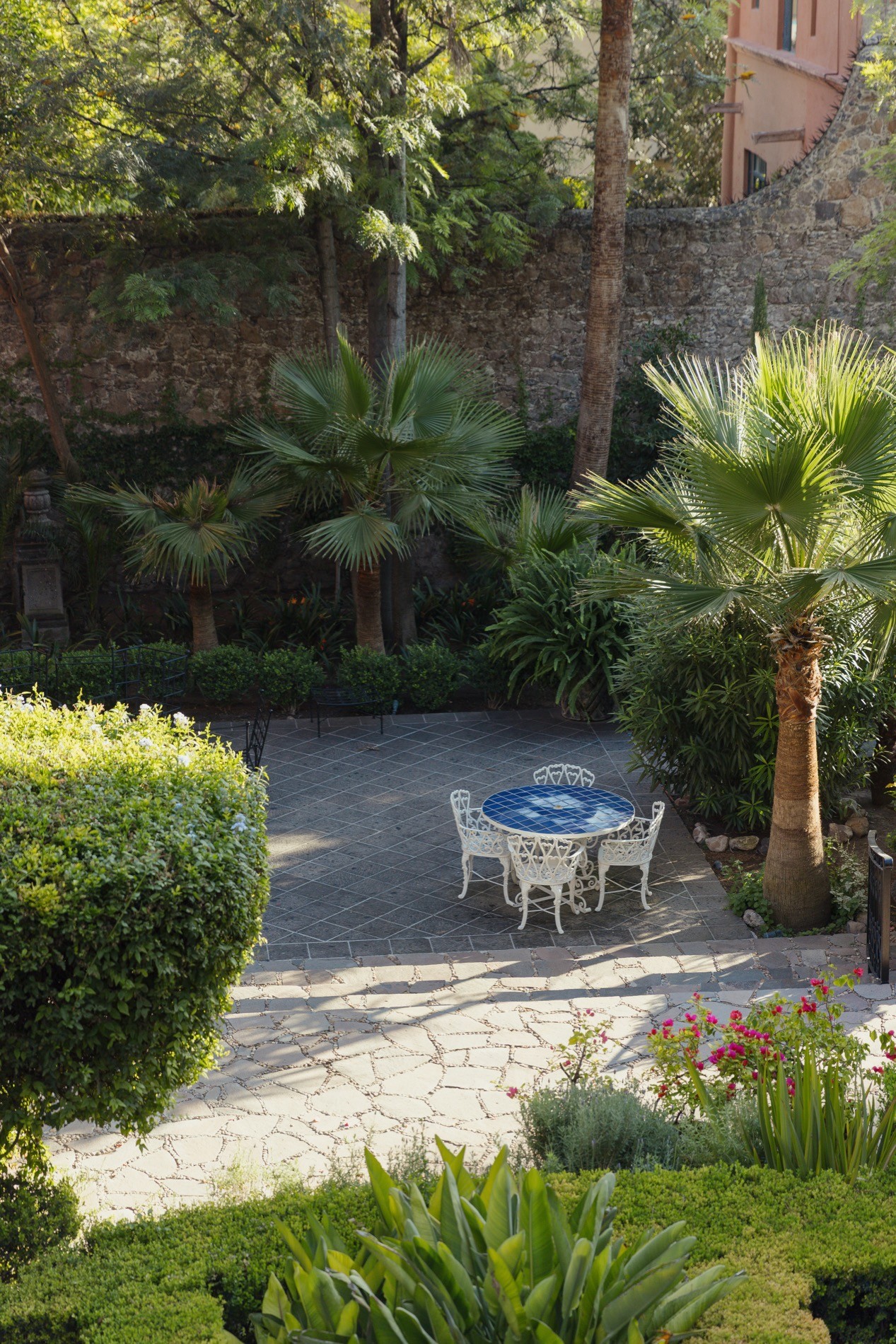 La Residencia San Miguel lush private garden with pool, manicured hedges, and palm trees