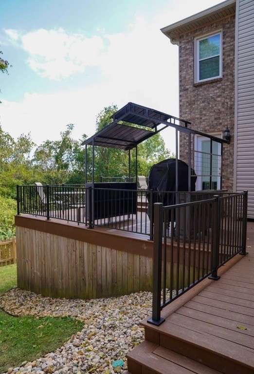 Modern kitchen with a wooden dining table, white chairs, and a hanging light fixture above.