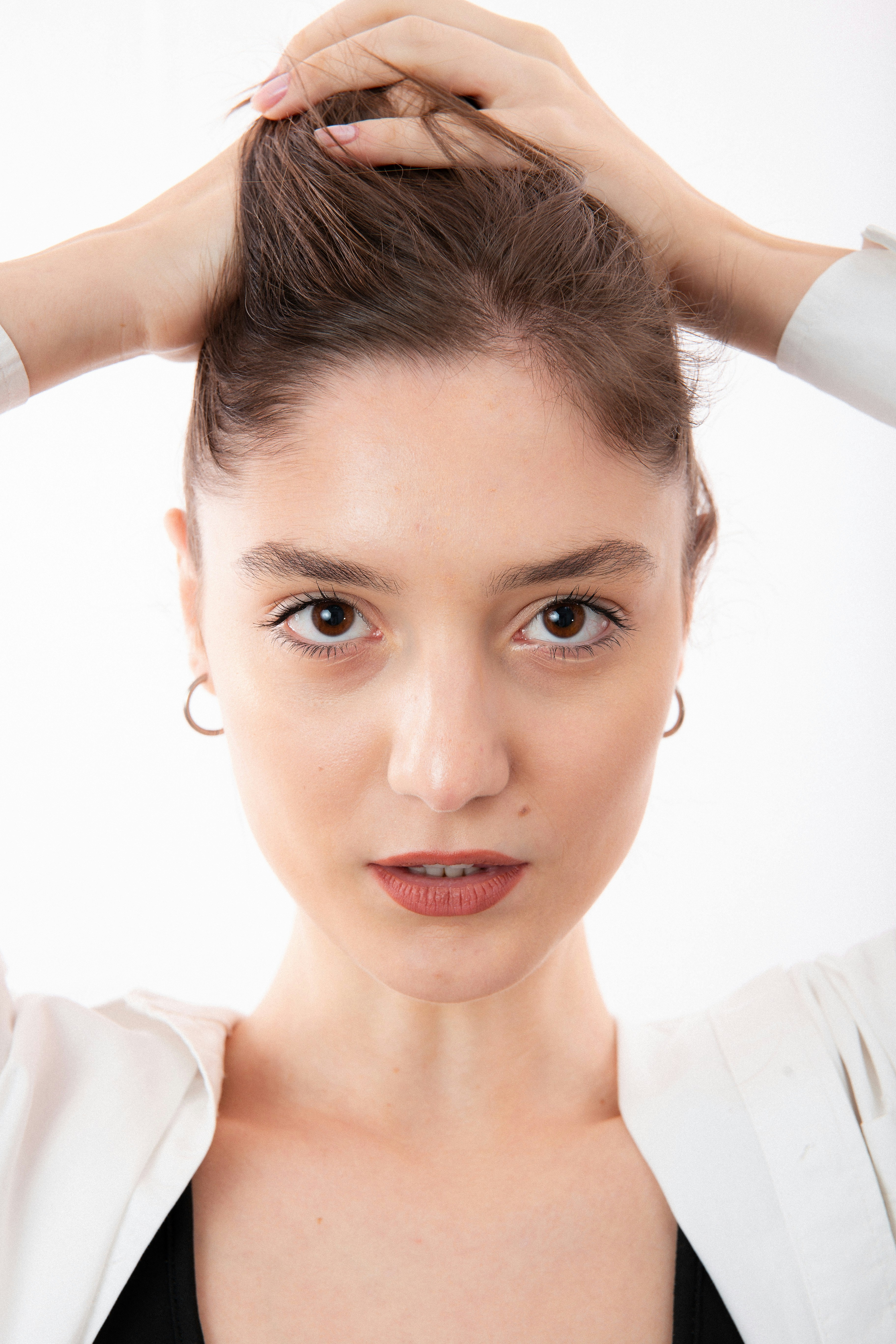 a woman is putting her hair in a bun