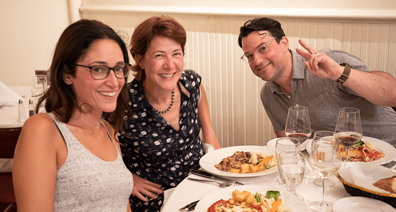 photo of a mana and two women at the dinner table