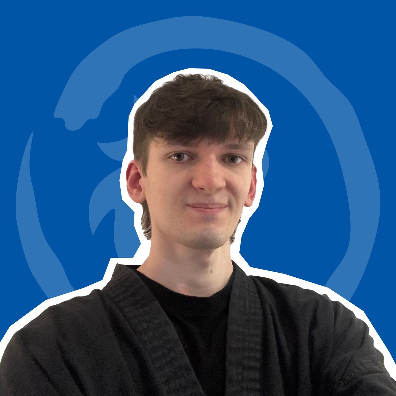 Dan in a black martial arts uniform against a blue background featuring the Dragon Spirit logo.