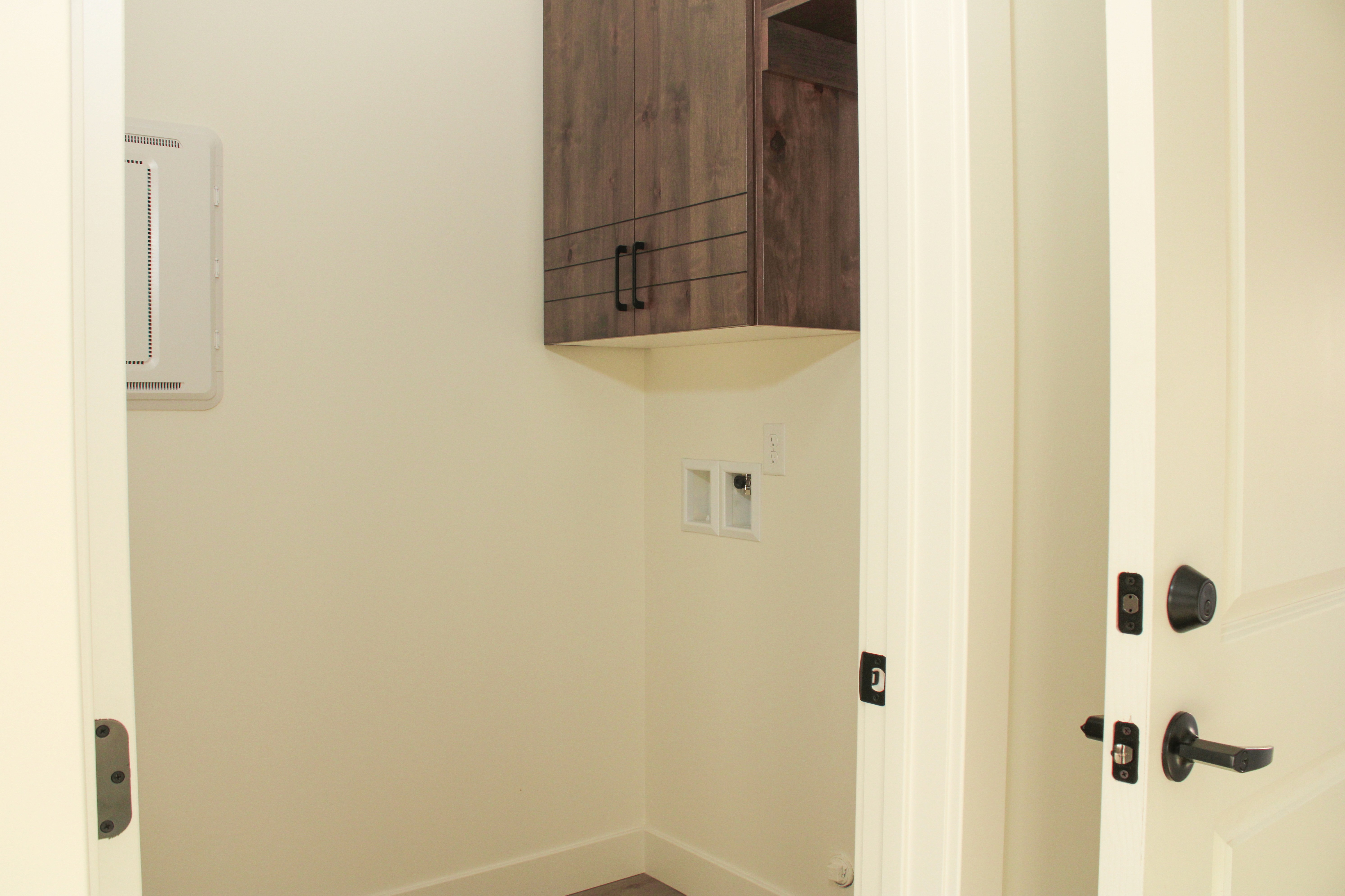 Laundry room inside the Golden Hour home in Hurricane, Utah featuring built-in cabinetry and a functional layout designed for everyday convenience.