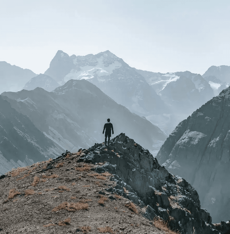Personne seule debout sur une crête montagneuse à 3 804 m d’altitude, entourée de sommets en arrière-plan. Des lignes blanches relient des mots-clés comme “ÉQUIPE”, “EFFORTS”, “ACTION”, “RÉUSSITE”, illustrant un réseau ou un parcours. En bas à droite, texte : “2 à 3 lives/jour”, “40 spécialistes sélectionnés”. Ambiance d’exploration, de connexion et d’accompagnement.