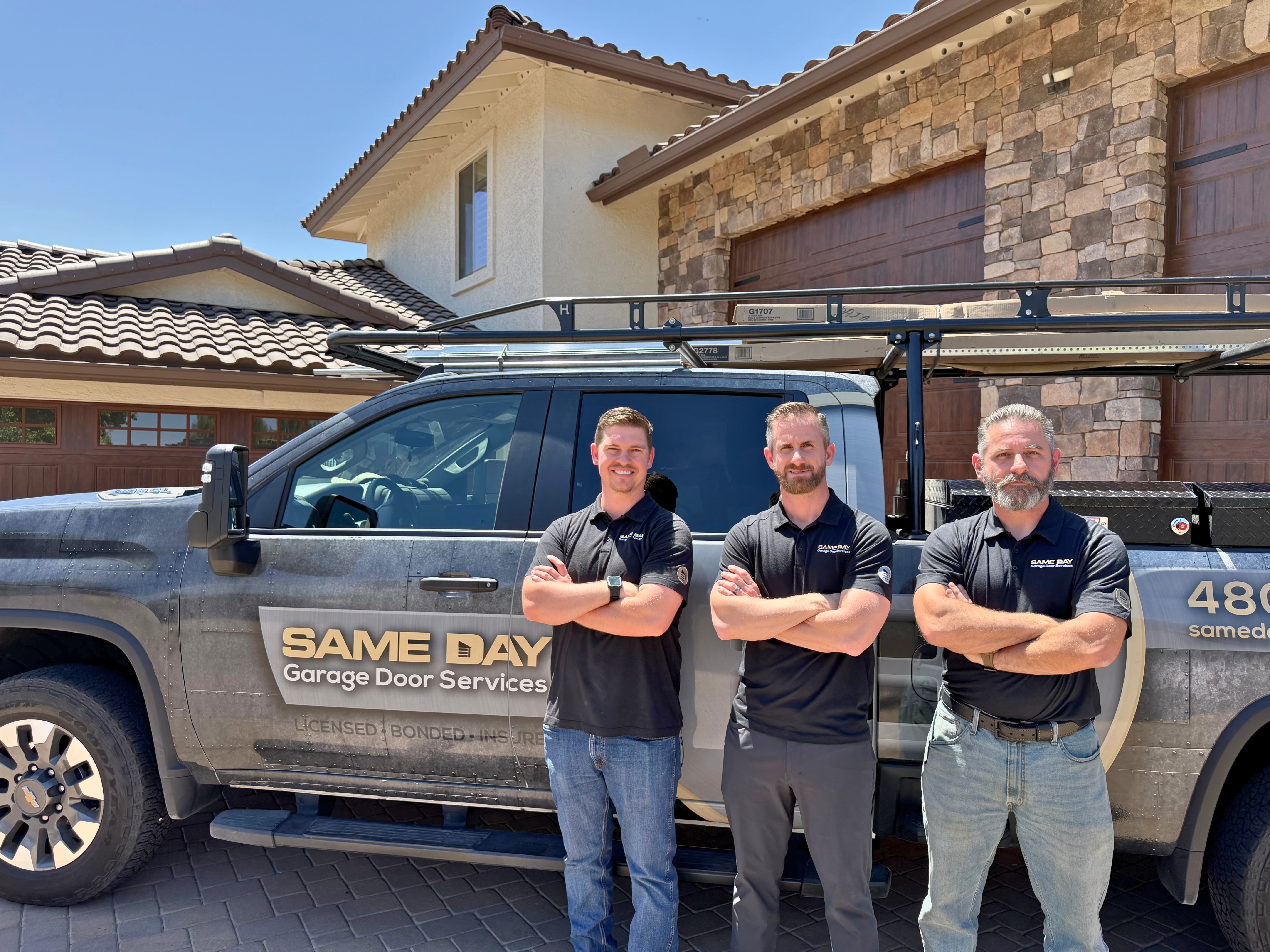 Trevor Leisek, Peter Brown, and Chris Brown standing in front of a branded Same Day Garage Door Services truck
