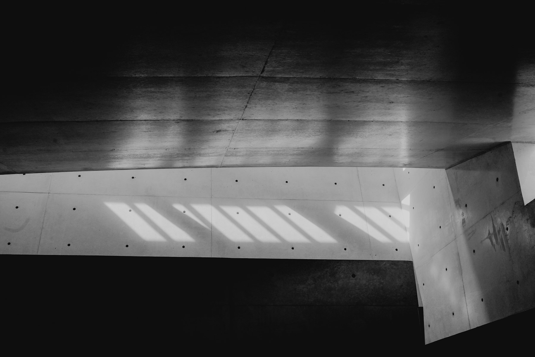 Stripes of light on a dark concrete floor and wall