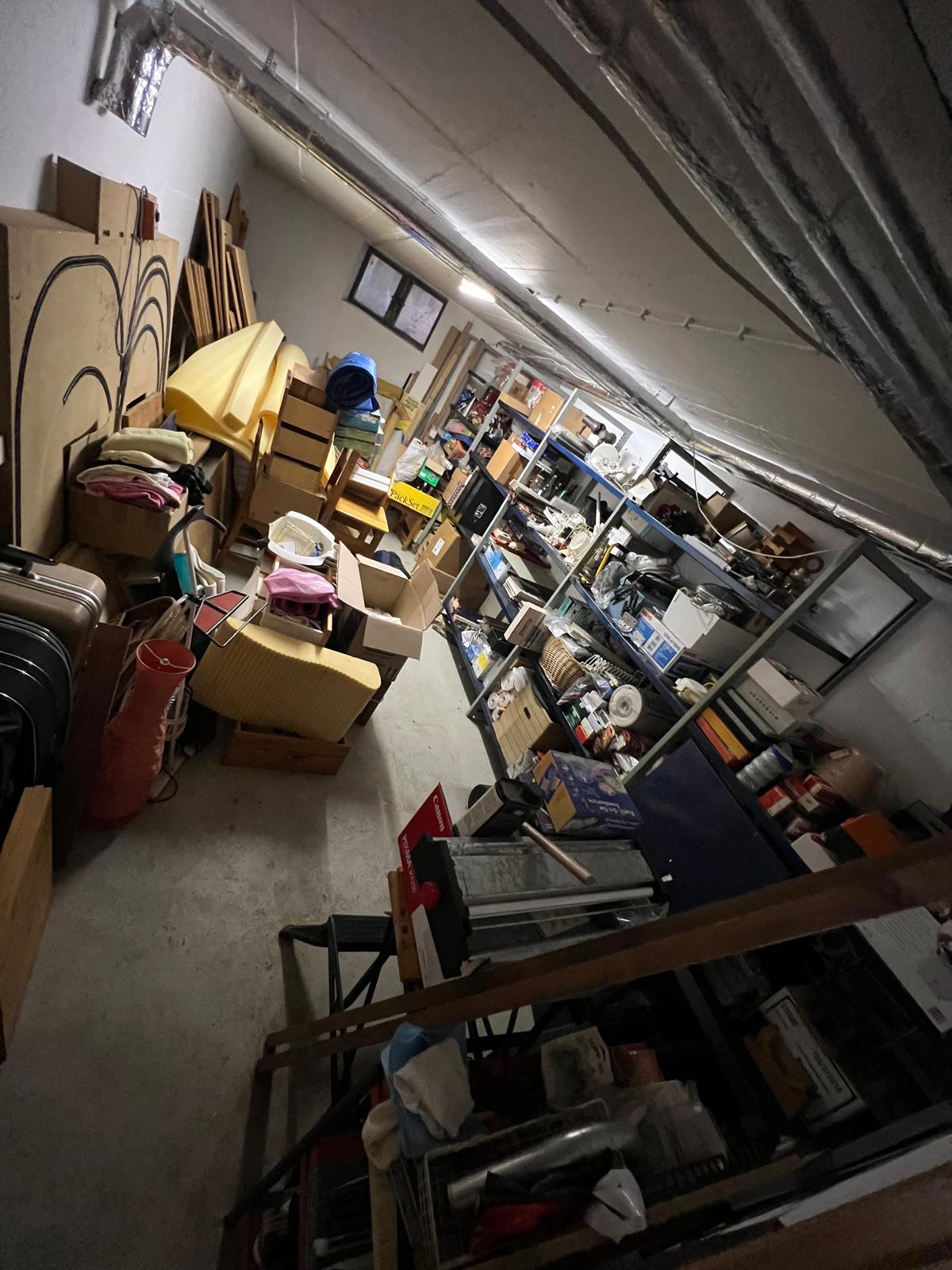 Entrümpelung Freising ein Mann ist an der Wand angelehnt und Grinst in die Kamere, Es scheint so als ob der Keller Entrümpelt wurde.