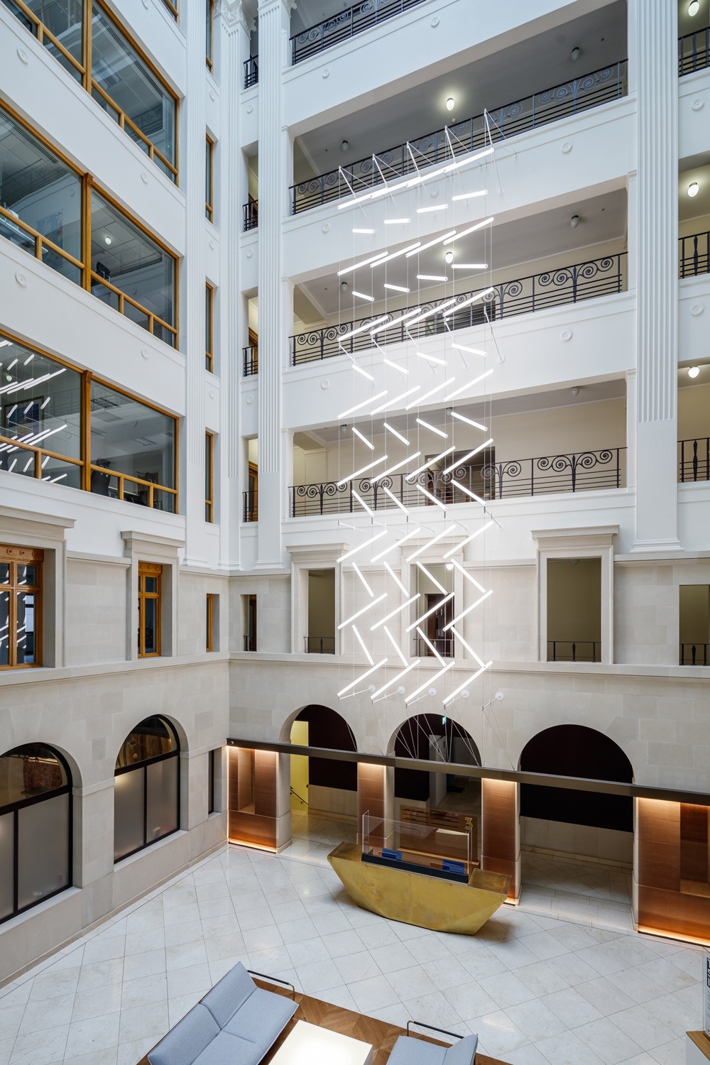 Suspended lighting installation in Brindley Place atrium featuring 60 custom acrylic LED units in a zig-zag formation