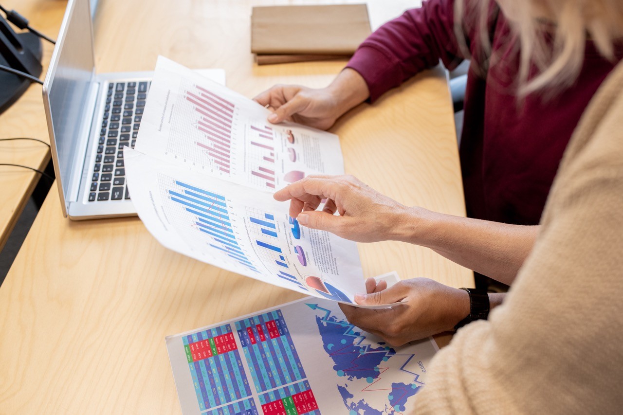 Two professionals reviewing investment data and graphs, symbolizing SAA Law's expertise in guiding foreign investment in Saudi Arabia.